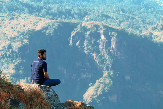man sitting on the mountain cliff photograph
