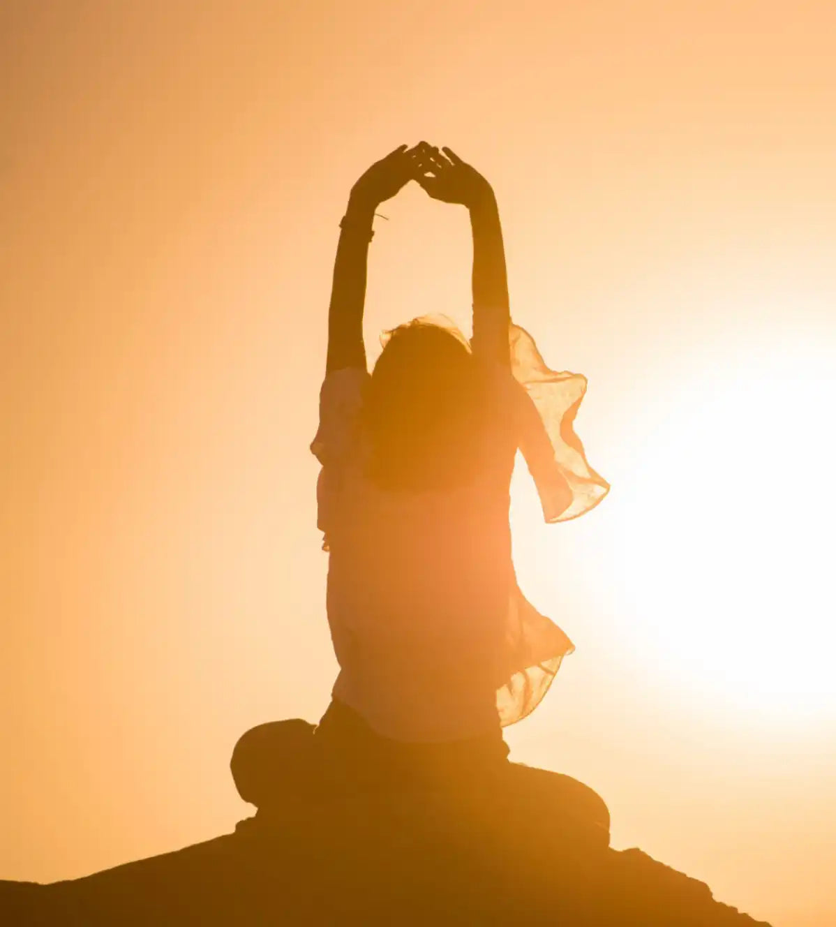 Silhouette of a woman in a yoga pose.